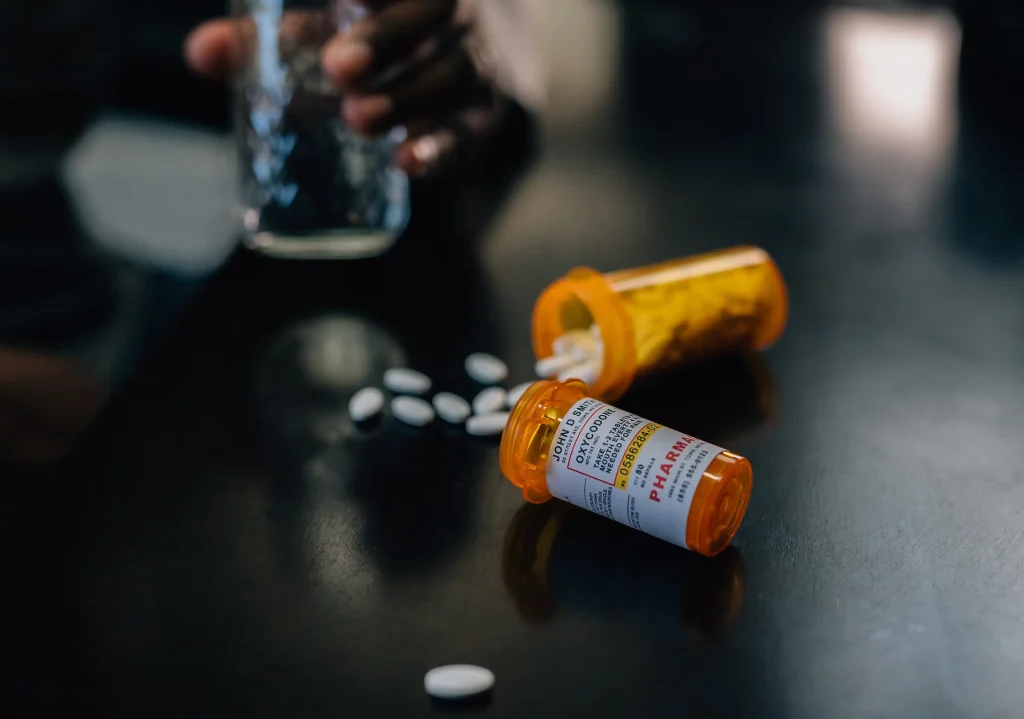 Prescription narcotic pills and bottles spilled on a table, representing opioid addiction treatment at California Detox & Recovery Center in Los Angeles.