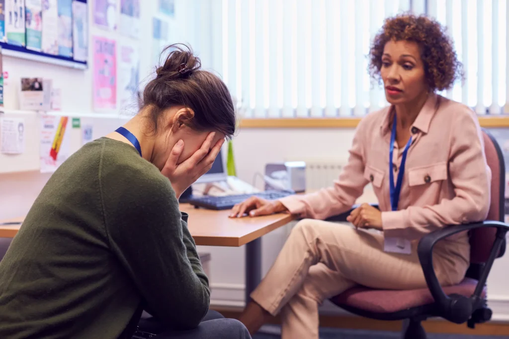 Woman with her face in her hands receiving mental health counseling and emotional support at California Detox & Recovery Center in Los Angeles.
