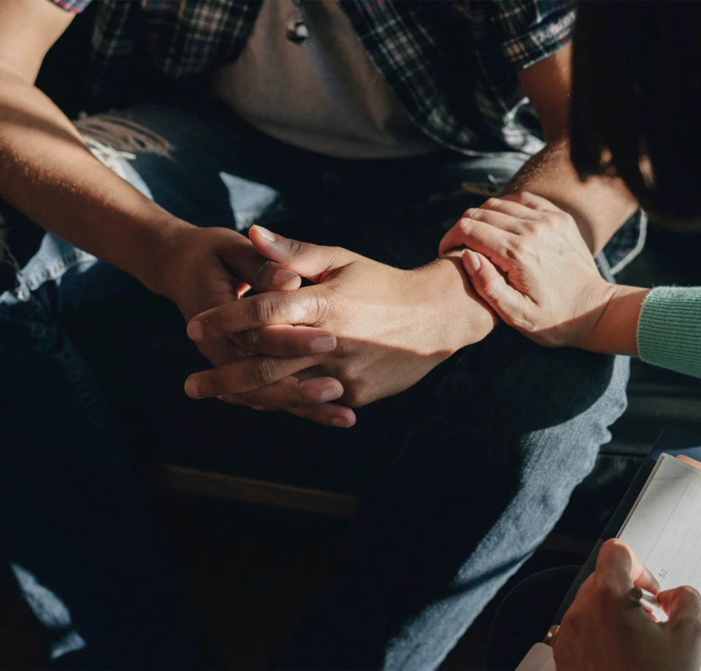 Hands holding together in family therapy, representing emotional support in addiction recovery at California Detox & Recovery Center in Los Angeles.