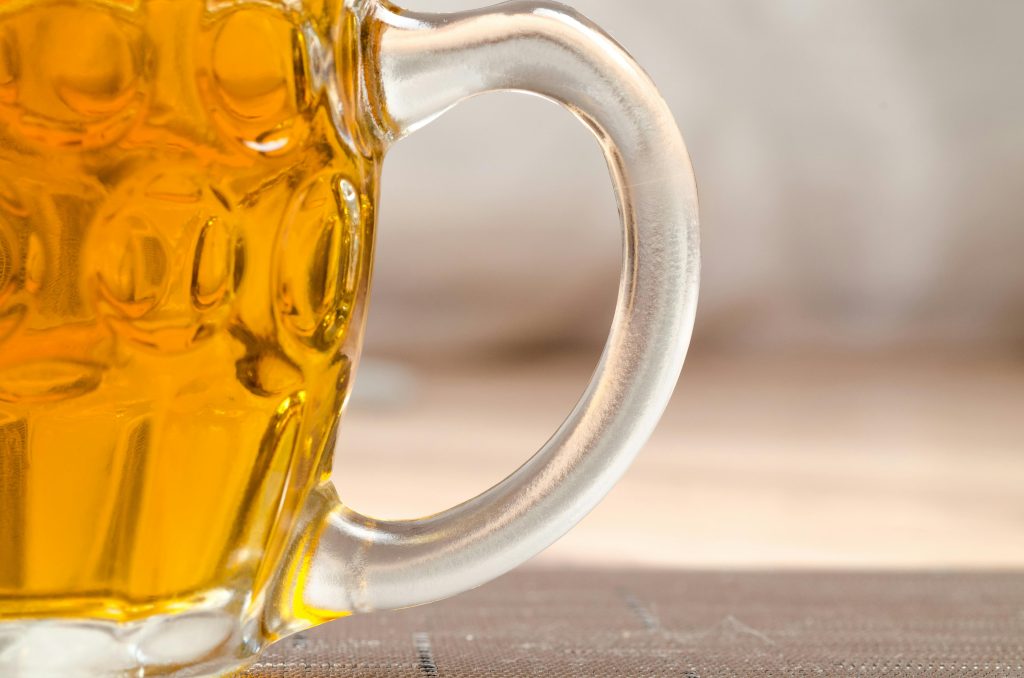 Close up of a glass of beer representing the dangers of alcoholism during Oktoberfest.
