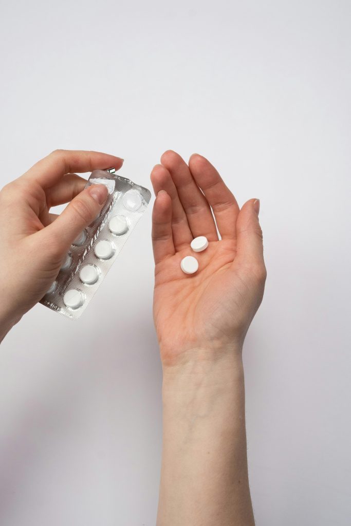 Close up of a person pouring white pills into ones hands, symbolizing the dangers of prescription opioid addiction in Los Angeles.