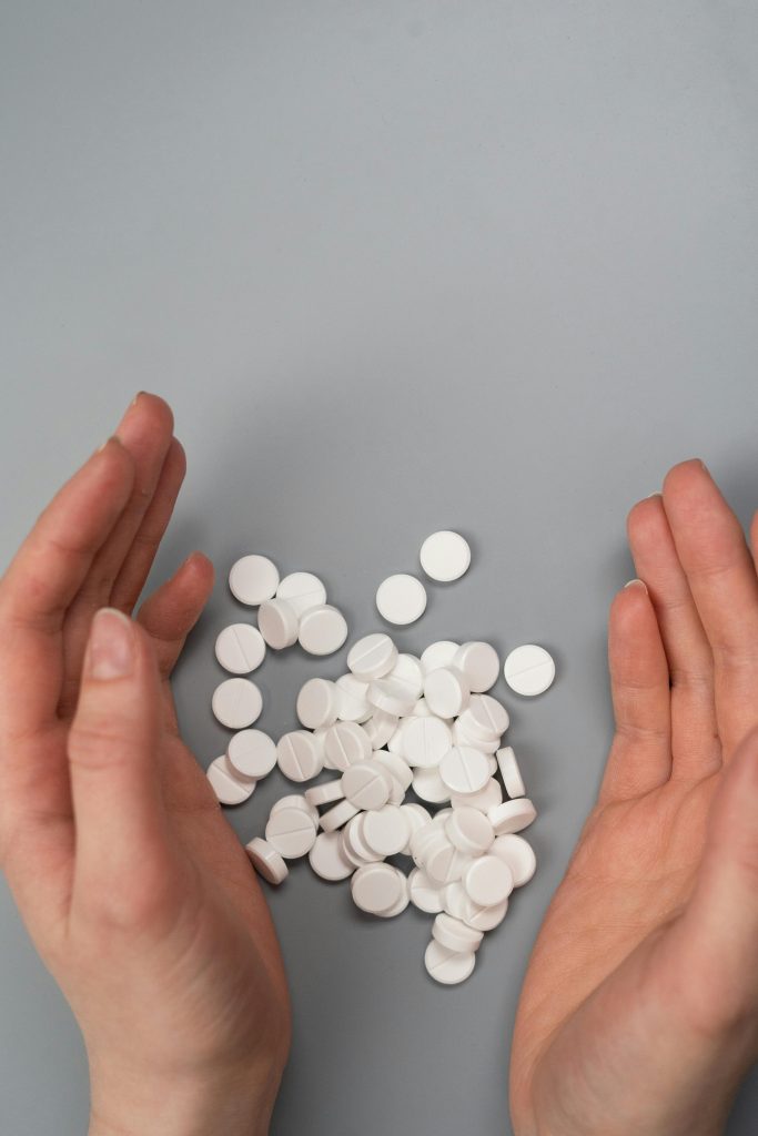 White pills laid out between a persons hands symbolizing opioid addiction in Los Angeles.
