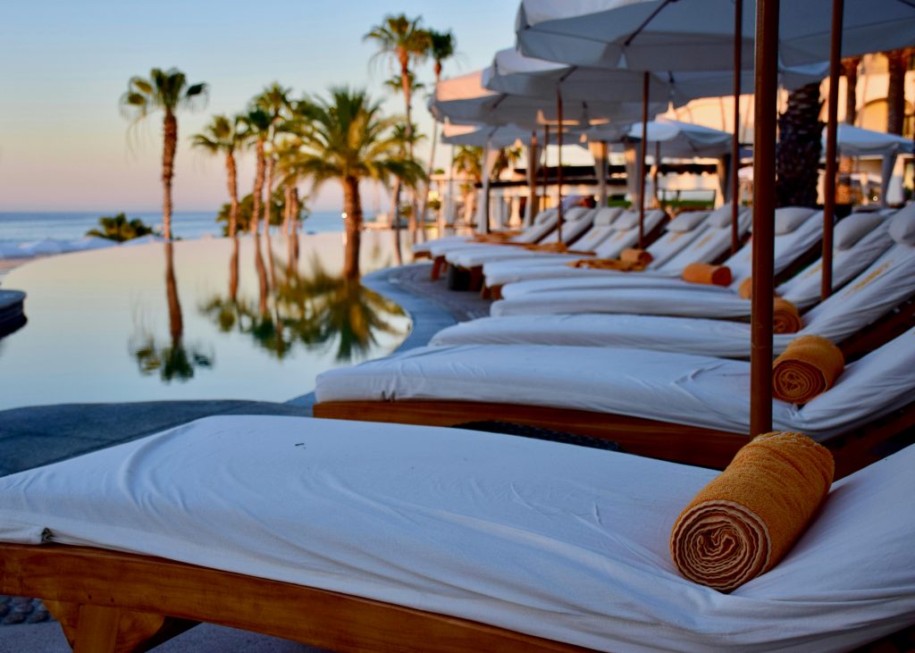 Luxury beachfront setting with lounge chairs and palm trees, representing residential treatment at California Detox & Recovery Center in Los Angeles, California.