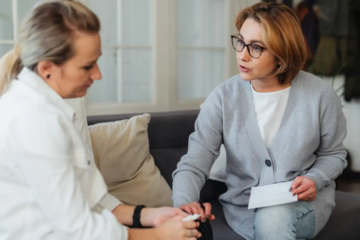 Woman Holding Another Womans Hand and Talking to Her