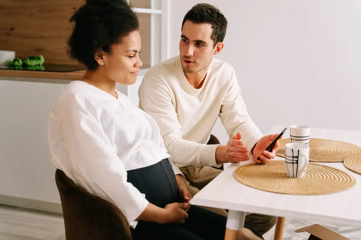 Man Holding Cellphone While Talking to a Woman