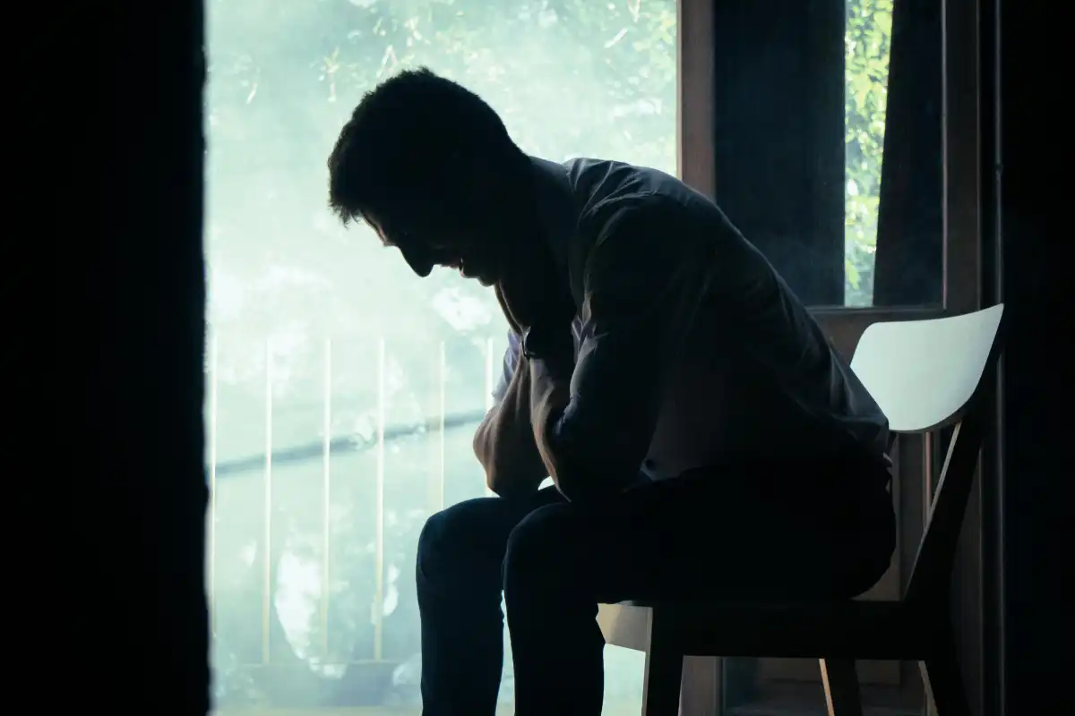 Silhouette of a Man Sitting Indoors in Thoughtful Pose